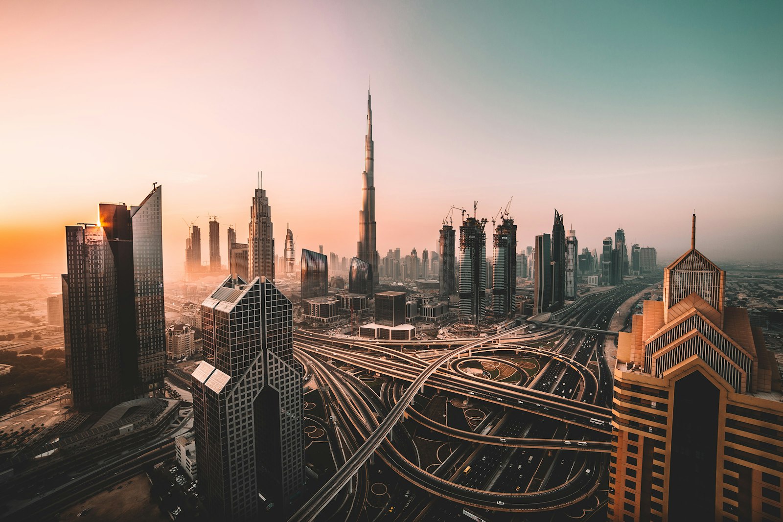 The Dubai skyline at golden hour, with the Burj Khalifa above a web of highways
