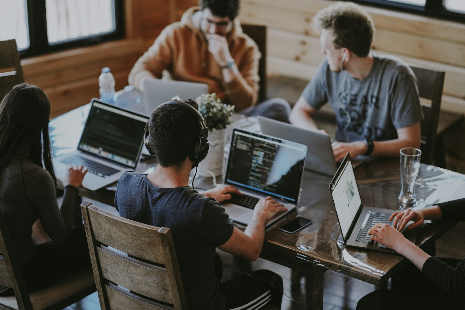 A team working on laptops around a wooden table